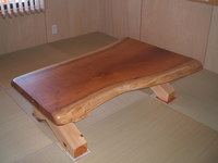 造作のけやきの座卓。趣のある木目と曲面が畳の間によく合います。