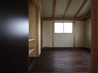 ご夫婦の寝室です。濃い色目の床材(神代黒柿 塗油仕上げ)を貼ることでシックな印象を醸し出しています。適度な暗さがお休みになるのに最適です。