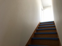 工事後の階段です。
2階リビングに設けた室内窓から光を採り入れ、また、白い壁紙を貼ることで大変明るくなりました。