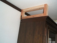 天井と食器棚の隙間に木枠をあてがって家具の固定をしました。木枠は金具で家具と固定しています。