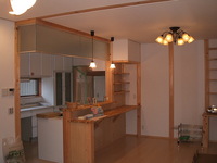 対面キッチンの背面に食事カウンター、配膳カウンターを設け、レンジフード背面の壁には棚を設けました。
